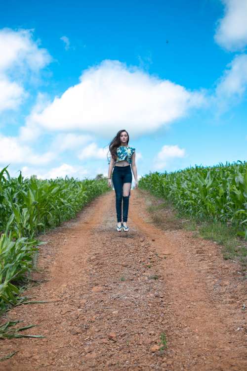 girl jumping field farm crops