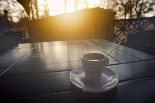 coffee cup saucer table sunset