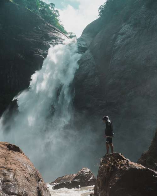 man rocks waterfall male adventure