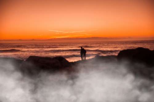 ocean sunset couple people silhouette