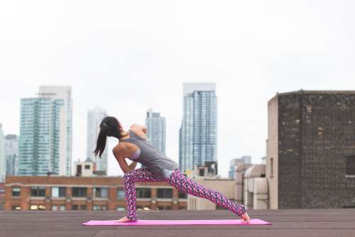 city stretched woman yoga outdoors