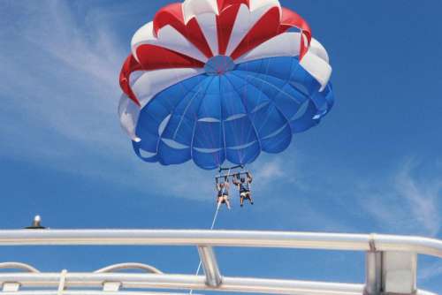 parachute blue sky clouds people