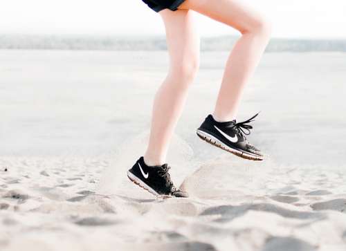 woman sneakers jumping summer beach