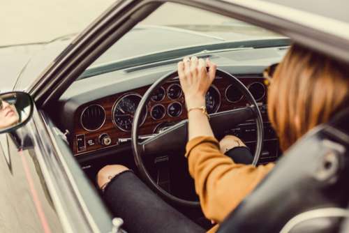 woman driving vintage car sterring