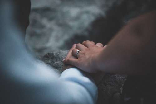 man woman hands holding ring