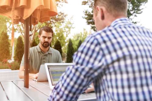 man outside working laptop tablet