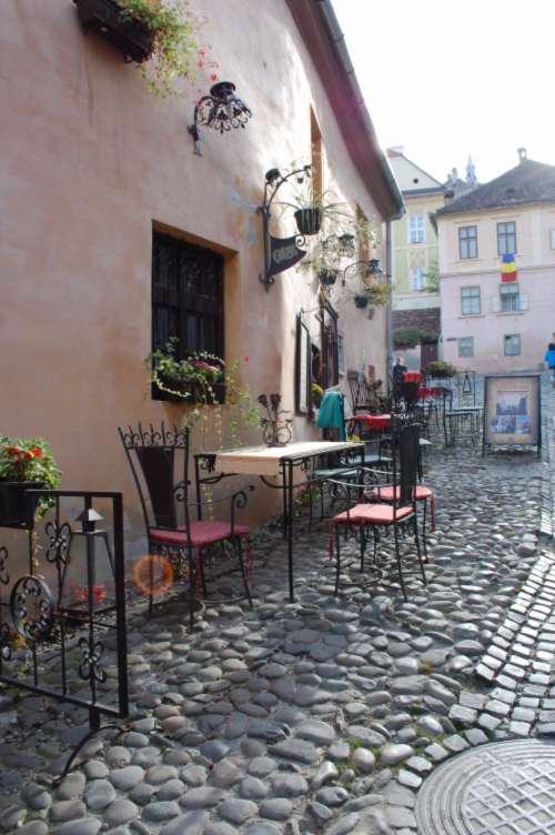 romania cafe cobbles side-street chair