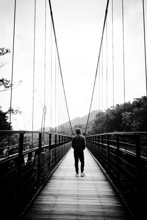 man walking bridge black & white people