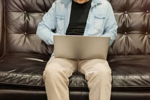 couch man laptop working developer