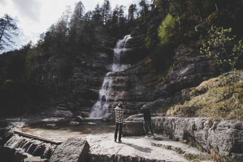 photographing waterfall mountain people man