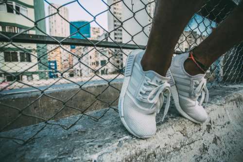 sneakers shoes feet concrete chainlink