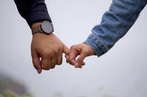 people couple holding hands watch