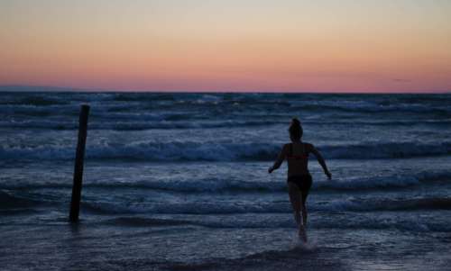girl running beach ocean water