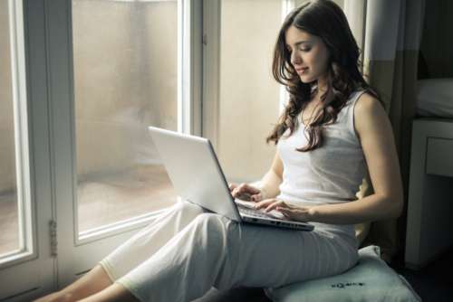 woman laptop work pyjamas window