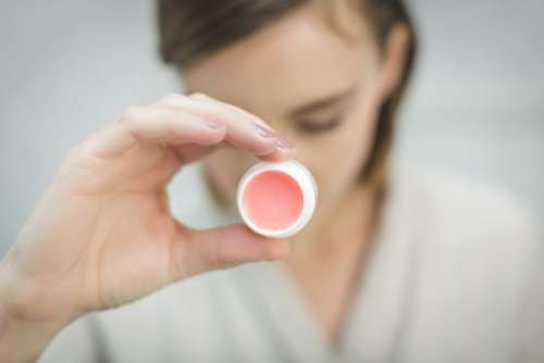 woman holding pink lipbalm fashion