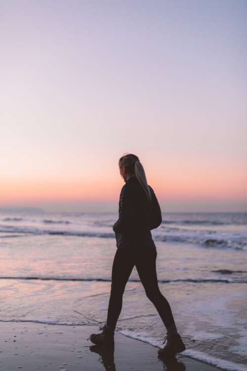 walking beach woman silhouette waves