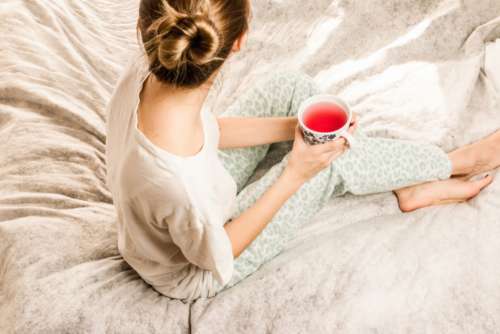 woman bed drink tea food