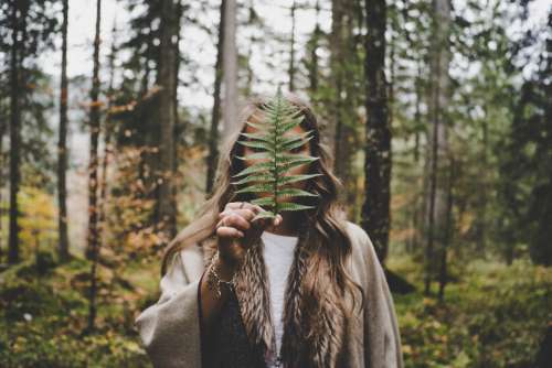 woman hiding leaf tree adventure