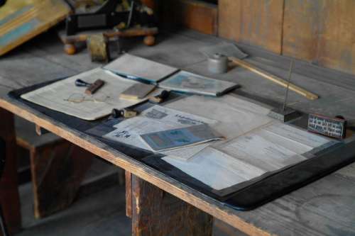 wooden table papers eyeglasses study