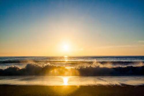 sunset sun rays beach sand ocean