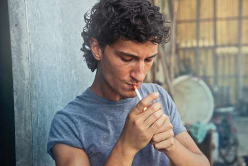 man lighting cigarette smoke male
