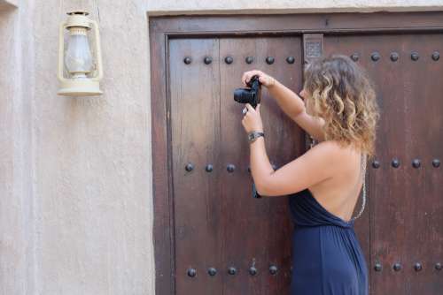 woman photographing lantern blue dress