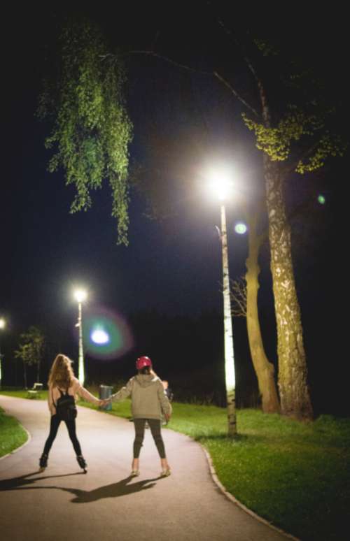 woman rollerblading night couple holding hands