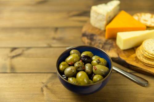 olives cheese crackers table wood