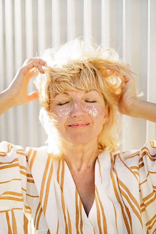 woman scratching hair blonde smile
