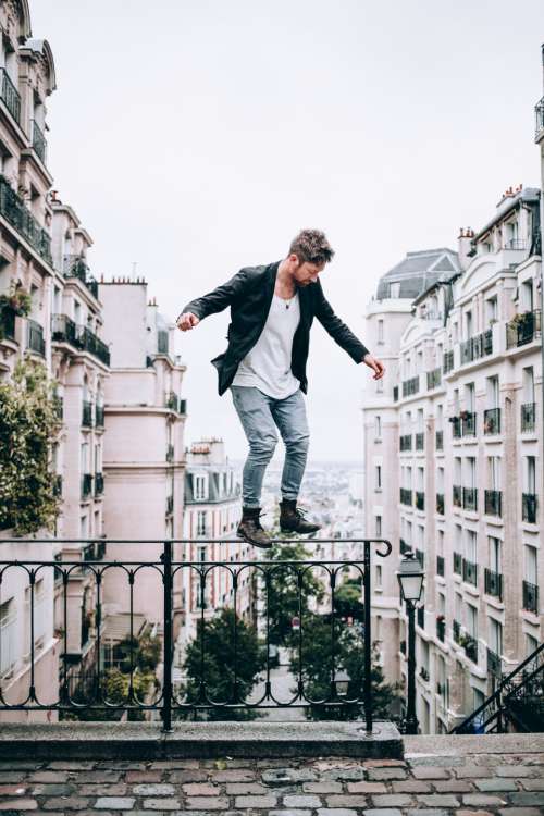 man fashion balancing city buildings