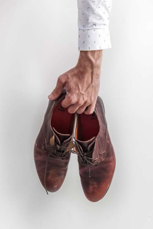 man holding shoes classy dress shoes