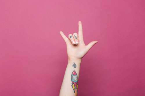 A Tattooed Hand Doing The Sign For I Love You Photo