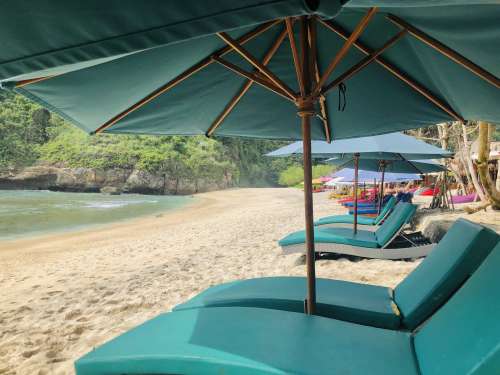 Blue Sun Shades And Deck Chairs On A Golden Sandy Beach Photo