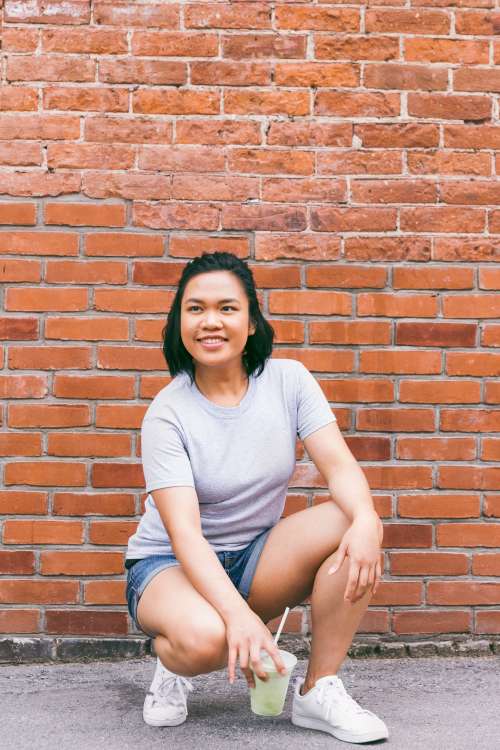 Crouching In Front Of Brick Wall Photo