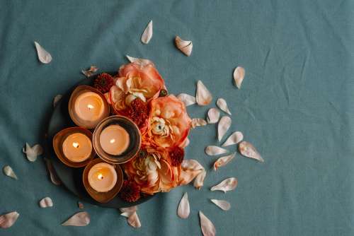 Flower Petals Huddled Together Near a Candle Photo