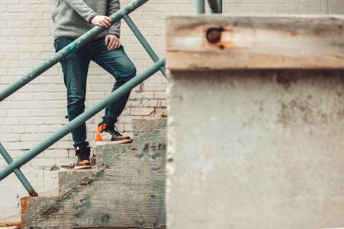 Model Poses On Cement Stairs In Denim And Sneakers Photo