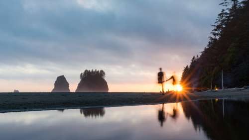 people walking beach sunset sunlight