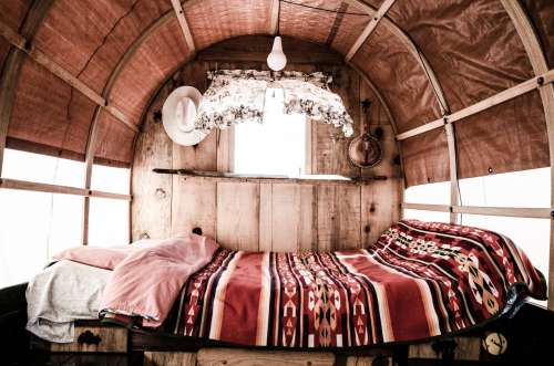 A Bed With A Blanket Inside A Caravan Photo