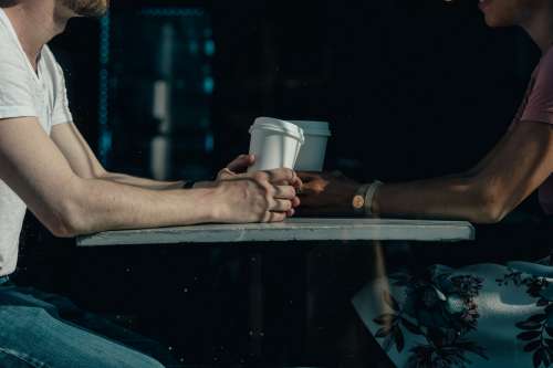 A Couple Chat Over Coffee Cups On A Sunny Day In A Cafe Photo