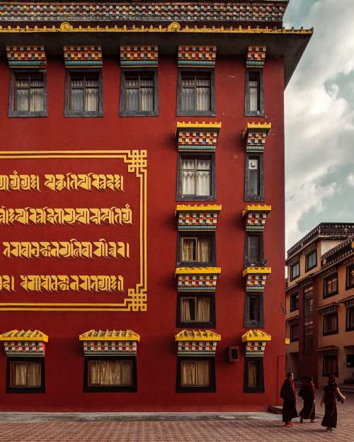 A Crimson Building With Gold Writing On The Walls Photo