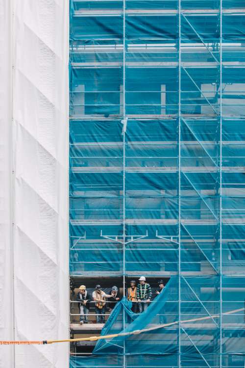 A Group Of Builders On Scaffolding Photo