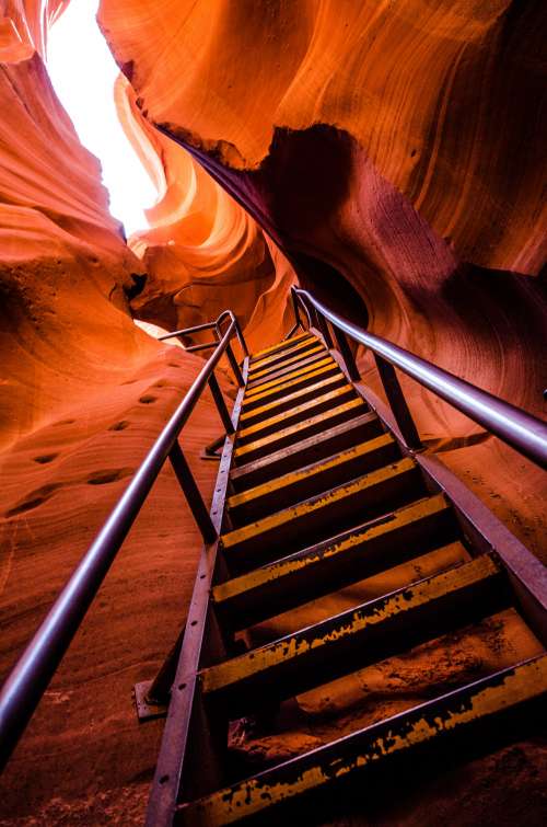 A Ladder Scales The Steep Sides Of A Red Sandstone Cave Photo