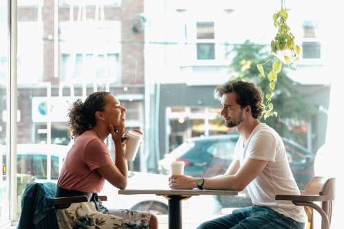 A Man And A Woman Share A Smile Over Coffee Photo