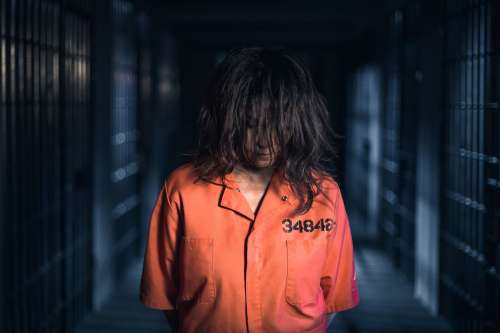 A Prisoner Standing In Orange Jumpsuit Photo