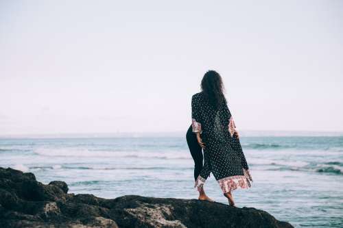 A Woman In Flowing Patterned Robe Stands By Waters Edge Photo
