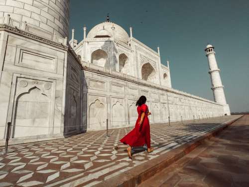 A Woman In Red Passes The Taj Mahal Photo