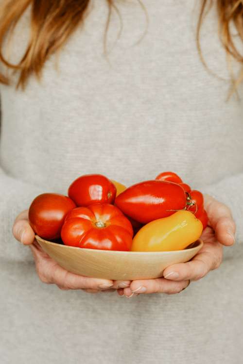 A Woman With A Bowl Of Tomatoes And Peppers Photo