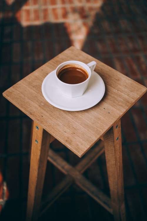 Long Espresso Sits On A Wooden Stool Photo