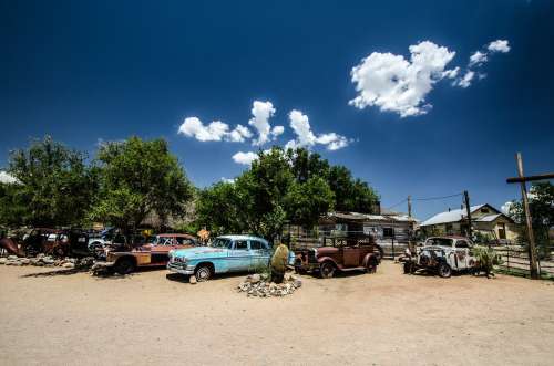 Old Rusty Cars Sit Under Trees In The Desert Photo
