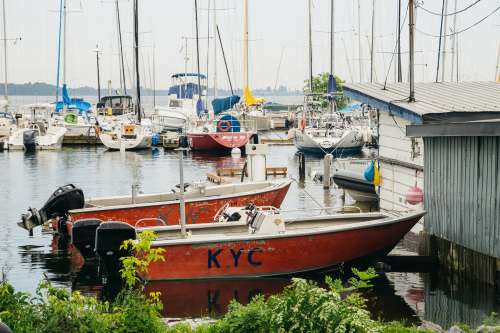 Small Pair Of Boats Docked By Boathouse Photo